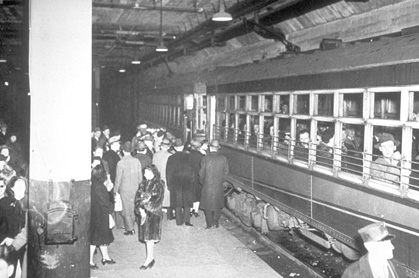 Crowds board commuter trains at City Hall station during WWII (circa 1944)