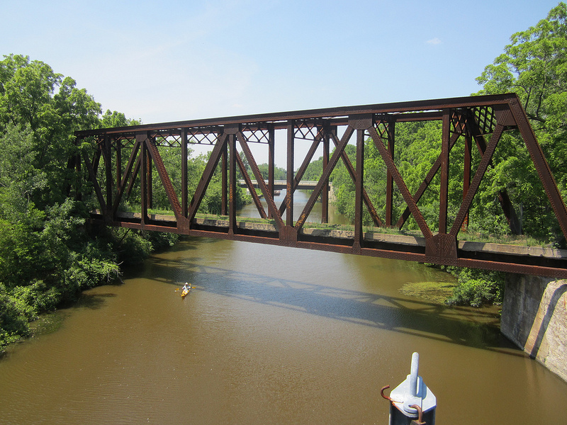We look westward and see an old train bridge and a kayaker enjoying the canal. [PHOTO: Ryan Green]
